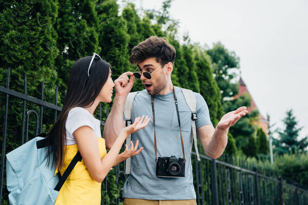 shocked man and asian woman talking and looking at each other 