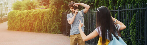 panoramic shot of man taking photo of brunette woman