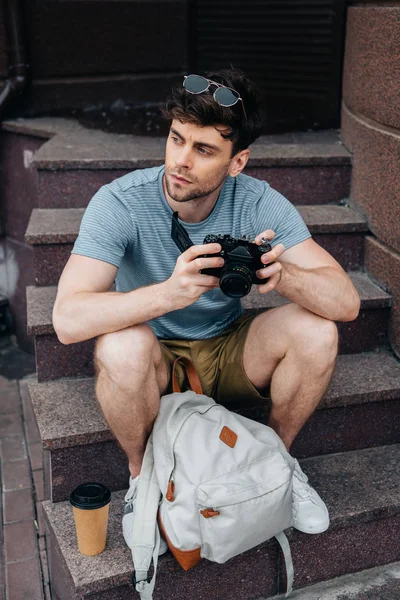 Homem Bonito Óculos Segurando Câmera Digital Olhando Para Longe — Fotografia de Stock