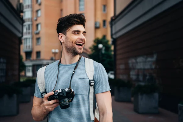 Hombre Guapo Camiseta Sosteniendo Cámara Digital Mirando Hacia Otro Lado — Foto de Stock