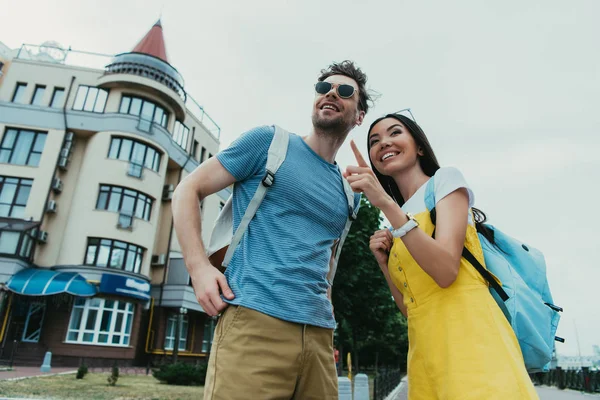 Pohledný Muž Který Hledí Pryč Asijská Žena Ukazující Prstem — Stock fotografie