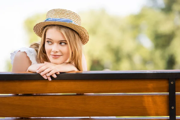 Όμορφο Κορίτσι Ψάθινο Καπέλο Χαμογελά Ενώ Κάθεται Στο Παγκάκι Και — Φωτογραφία Αρχείου