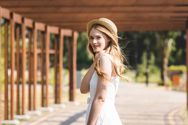 드레스와 모자에 아름다운 소녀의 선택적 초점은 산책과 카메라를보고 — 스톡 사진