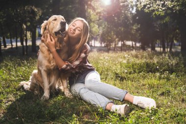 altın retriever petting ve köpek bakarken gülümseyen güzel kız tam uzunlukta görünümü