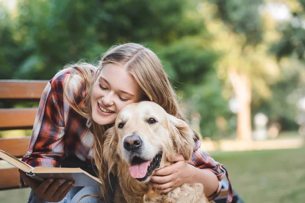 Menina Bonita Roupas Casuais Leitura Livro Abraçando Golden Retriever Enquanto — Fotografia de Stock