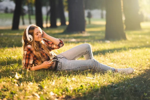 햇빛에 초원에 헤드폰에 음악을 캐주얼 아름다운 여자의 길이보기 — 스톡 사진