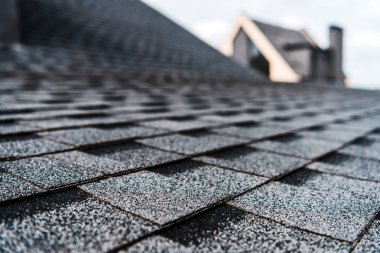 selective focus of grey shingles on rooftop of building  clipart