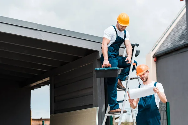 Hermoso Constructor Señalando Con Dedo Papel Cerca Feliz Compañero Trabajo —  Fotos de Stock