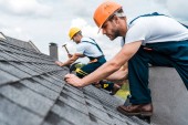 selektivní zaměření pohledného handmana oprava střechy se spolupracovníkem 