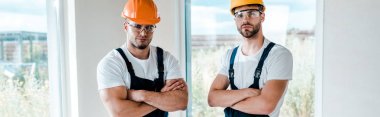 panoramic shot of handsome handymen standing with crossed arms  clipart