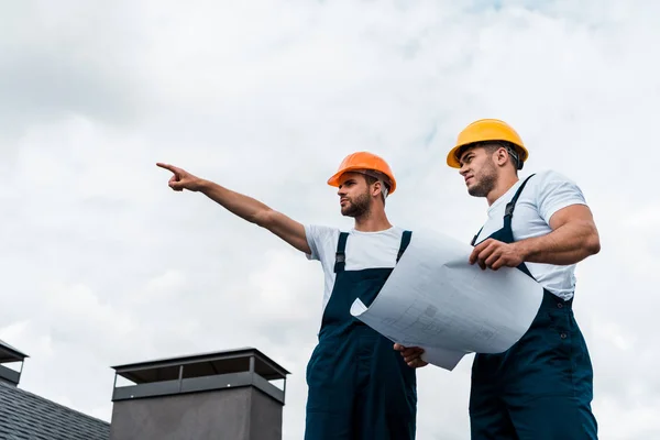 Low Angle View Handsome Architect Pointing Finger Coworker Helmet Holding — Stock Photo, Image