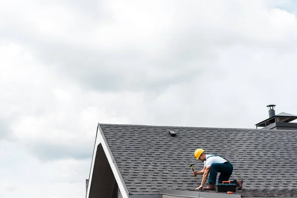 Repairman Hełmie Trzymając Młotek Podczas Naprawy Dachu — Zdjęcie stockowe
