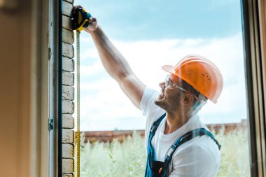 sarı ölçüm bandı ile neşeli handyman ölçüm penceresi seçici odak 