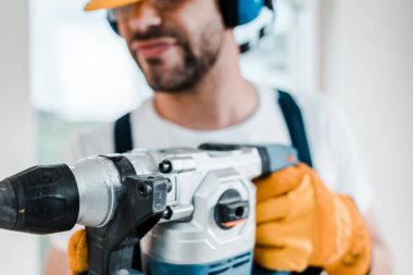 selective focus of handyman using hammer drill  clipart