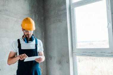 dijital tablet kullanarak gözlük ve kask yakışıklı handyman 