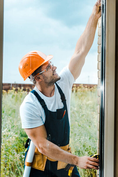 selective focus of happy handyman measuring window with measuring tape 