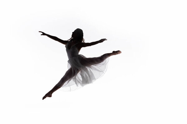 Young graceful ballerina jumping while dancing isolated on white