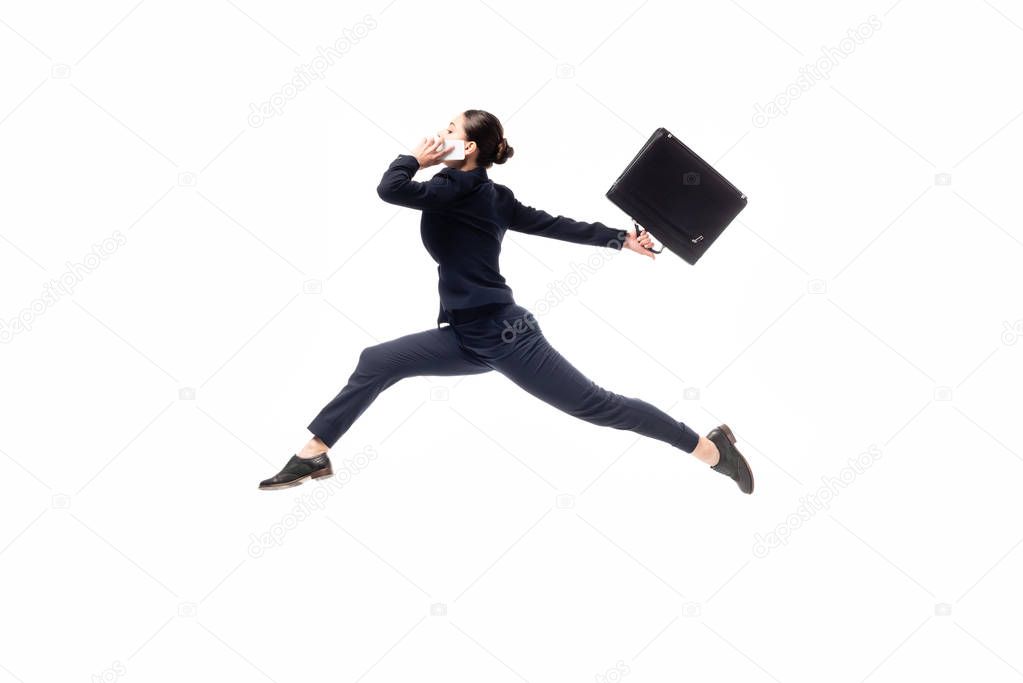 side view of businesswoman holding briefcase and talking on smartphone while levitating isolated on white