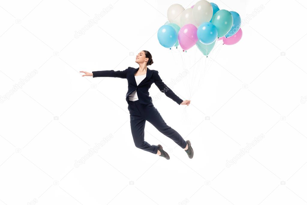 happy businesswoman levitating with festive balloons isolated on white