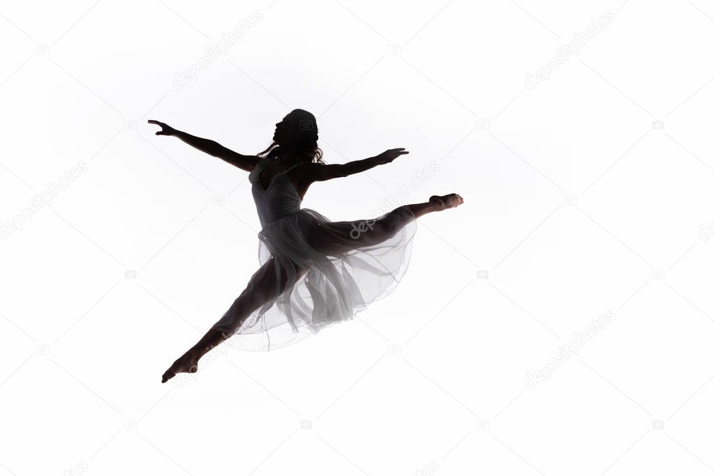 young graceful ballerina jumping while dancing isolated on white