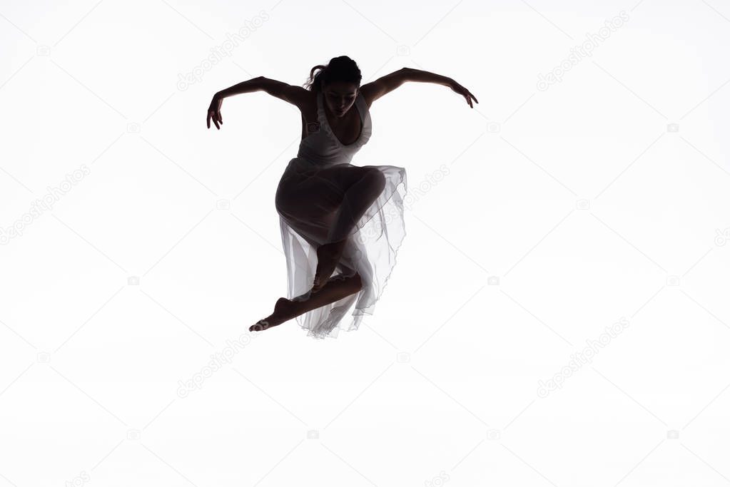 young, graceful ballerina jumping in dance isolated on white