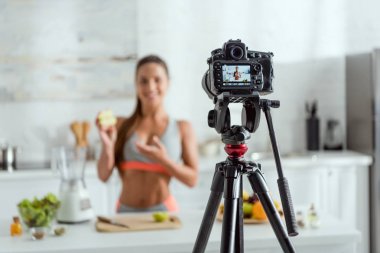 apple ve ekranda gesturing yarısını tutan mutlu kadın ile dijital kamera seçici odak 