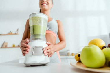 low angle view of woman preparing smoothie in blender  clipart