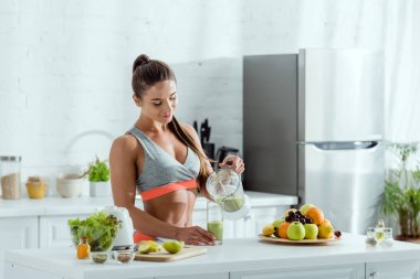blender gelen cam içinde smoothie döken spor ile mutlu kız 
