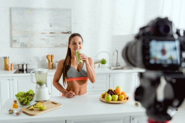 dijital kamera yakınında lezzetli smoothie tutan neşeli kız seçici odak 