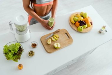 meyve yakınında lezzetli smoothie tutan kadının havai görünümü 