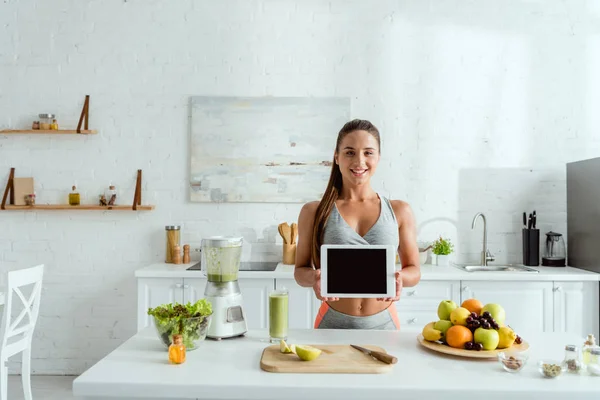 Chica Feliz Sosteniendo Tableta Digital Con Pantalla Blanco Cerca Mesa — Foto de Stock