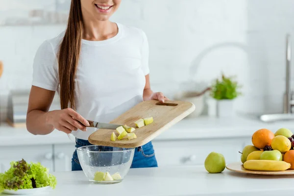 裁剪视图的快乐年轻女子把切片的绿色苹果在碗 — 图库照片