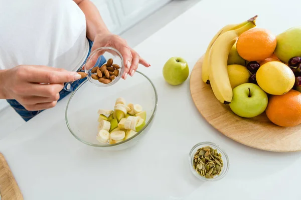 Cropped View Woman Adding Almonds Bowl Tasty Fruits — Stock Photo, Image