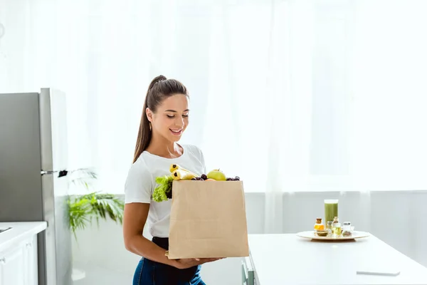 Gelukkig Jonge Vrouw Kijken Naar Papieren Zak Met Fruit — Stockfoto