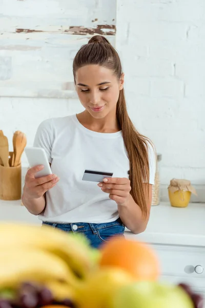 Selective Focus Cheerful Girl Using Smartphone Holding Credit Card — Stock Photo, Image
