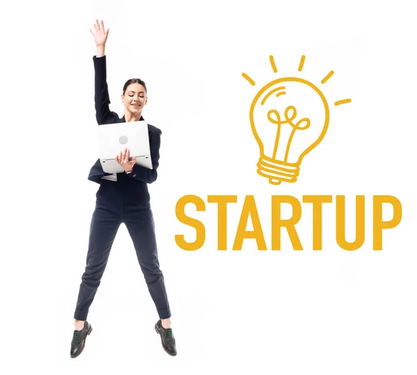 Smiling Businesswoman Using Laptop While Jumping Startup Word Drawn Electric — Stock Photo, Image