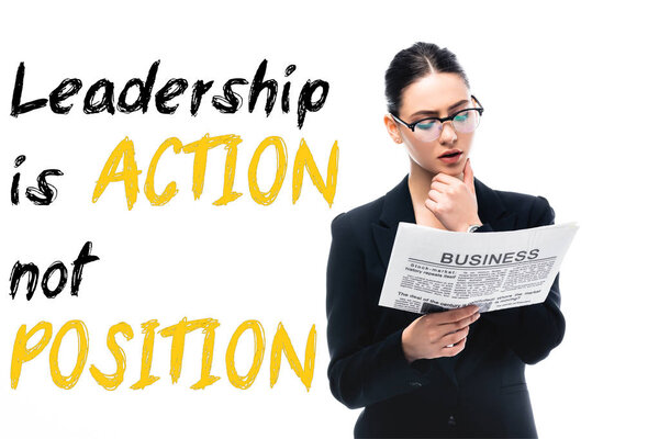 thoughtful businesswoman reading newspaper near leadership is action not position lettering isolated on white