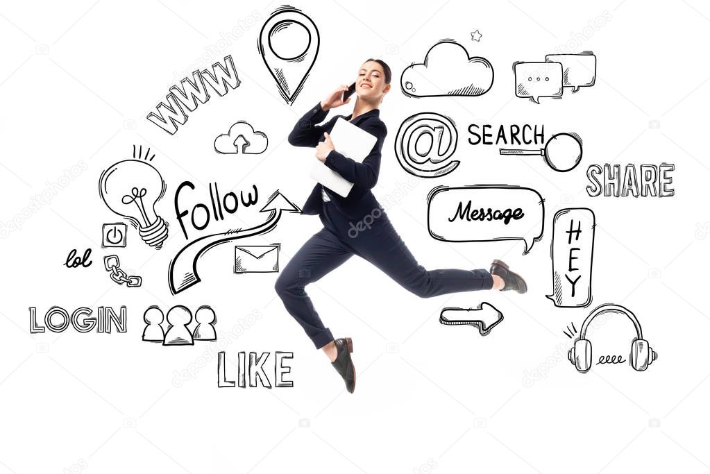 smiling businesswoman talking on smartphone and holding laptop while levitating near illustration with multimedia icons and logos isolated on white