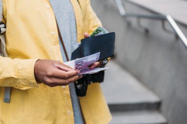 euro banknotları sayarken cüzdan tutan karışık ırk adam kırpılmış görünümü 