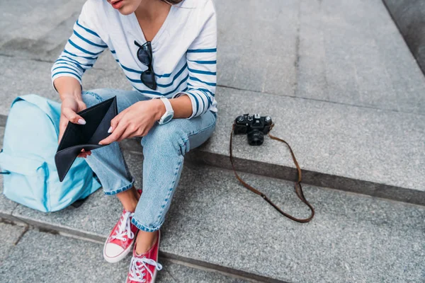 Vista Recortada Joven Mujer Sosteniendo Cartera Vacía Cerca Cámara Digital — Foto de Stock