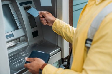 cüzdan tutarken atm makinekredi kartı koyarak karışık ırk adam kırpılmış görünümü 