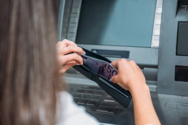 atm makinesi yakınında cüzdan para koyarak kadın kırpılmış görünümü 