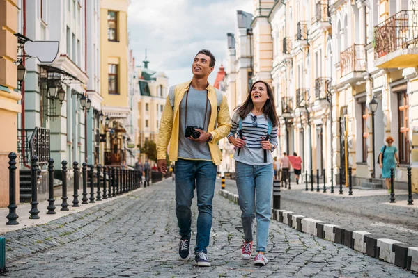 Feliz Viajero Caminando Con Guapo Racial Hombre Cerca Edificios —  Fotos de Stock