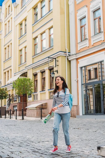 通りを歩き 地図を持っている幸せな若い女性 — ストック写真