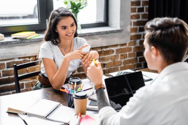çok ırklı arkadaşlar gülümseyen ve dairede birbirlerine bakarak seçici odak  