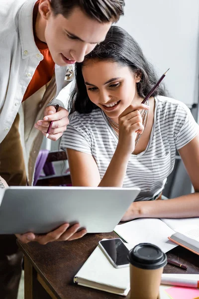 Wieloetnicznych Studentów Uśmiechając Się Patrząc Laptopa Mieszkaniu — Zdjęcie stockowe