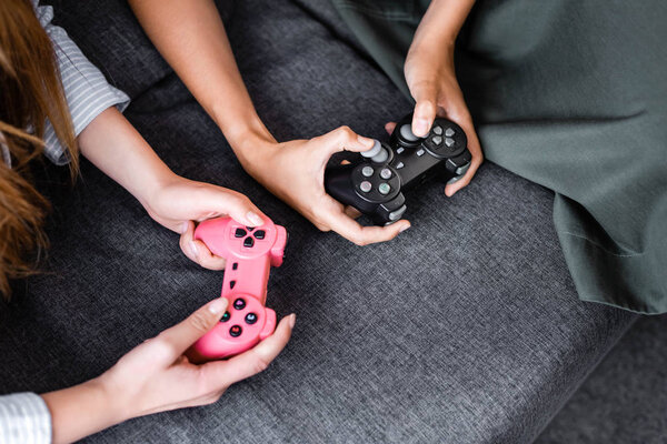 KYIV, UKRAINE - JULY 10, 2019: cropped view of multicultural friends playing video game in apartment 