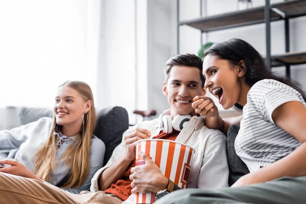 Multikulturní Přátelé Sedí Pohovce Jedí Popcorn Bytě — Stock fotografie