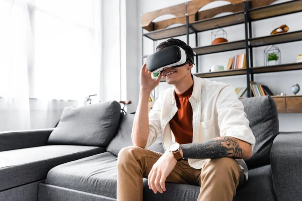 Άνθρωπος Ακουστικά Εικονικής Πραγματικότητας Που Κάθονται Στον Καναπέ Στο Διαμέρισμα — Φωτογραφία Αρχείου