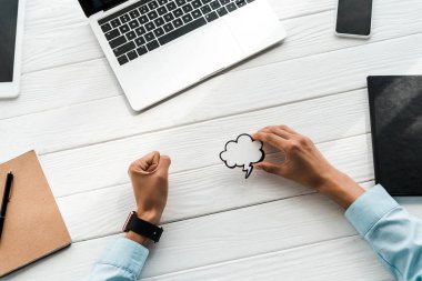 gadget'ların yanında çizilmiş bulutlu kart tutan kadının üst görünümü